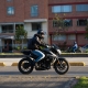 Motorcyclist with a helmet on an avenue in the Colombian capital in the evening light.