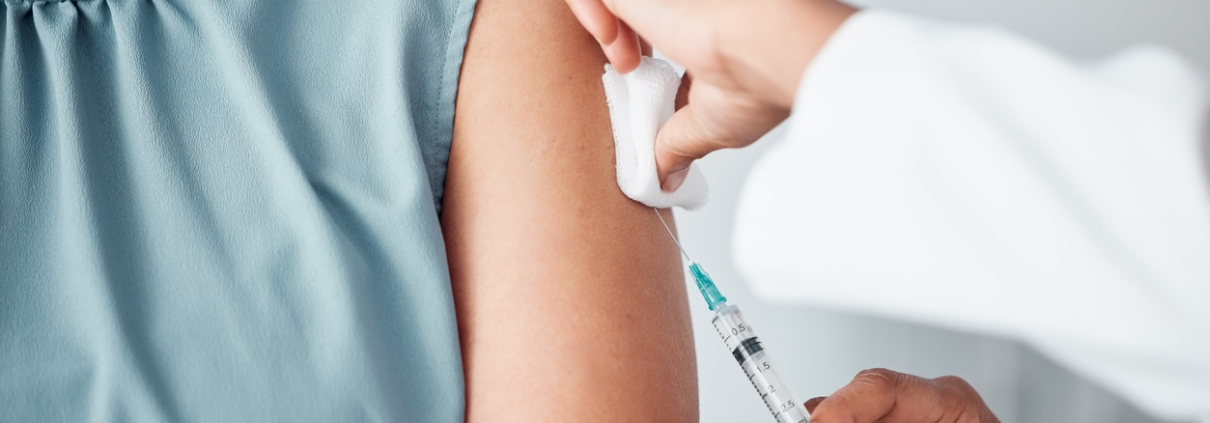 Hands, medical and doctor with patient for vaccine in a clinic for healthcare treatment for prevention. Closeup of a nurse doing a vaccination injection with a needle syringe in a medicare hospital.