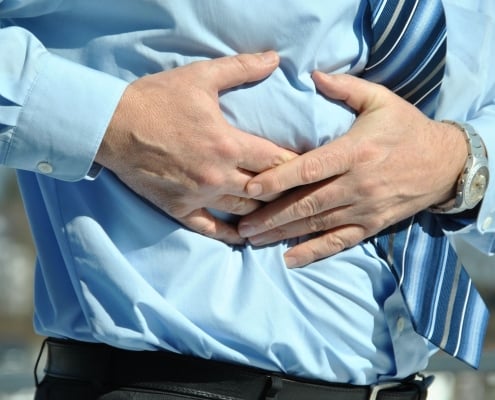 man grabbing his abdomen