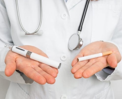 doctor holding a vape and a cigarette
