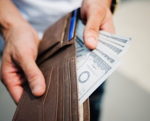 man pulling money out of his wallet