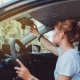 Safety driving woman adjust the car rearview mirror in interior before start travel trip every time.