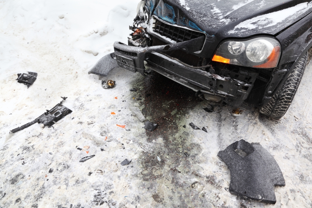 Broken black car on road in winter; crash accident.