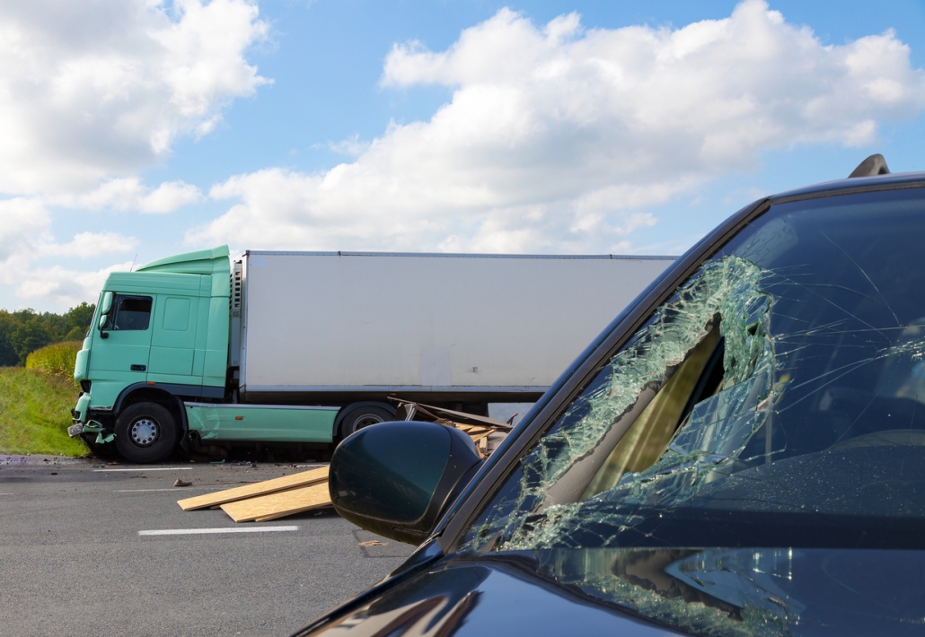 View of truck in an accident with car, cloudy sky