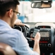 transportation concept - man using phone while driving the car