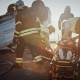 On the Car Crash Traffic Accident Scene: Rescue Team of Firefighters Pull Female Victim out of Rollover Vehicle, They Use Stretchers Carefully, Hand Her Over to Paramedics who Perform First Aid