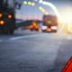 Red emergency stop sign (red triangle warning sign) and broken black SUV car.Selective focus with shallow depth of field.