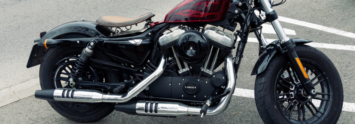 Contemporary motorcycle with shiny surface parked on parking in urban area on overcast day