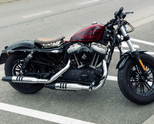 Contemporary motorcycle with shiny surface parked on parking in urban area on overcast day