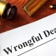 Document with title Wrongful Death o a wooden surface.