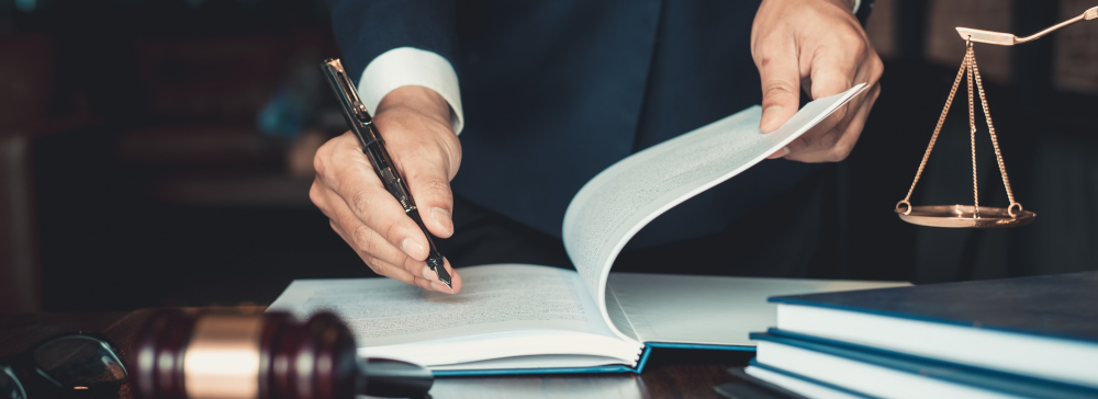 Justice and law concept. Gavel on sounding block in hand's Male judge at a courtroom, working with document law books, report the case on table in modern office.